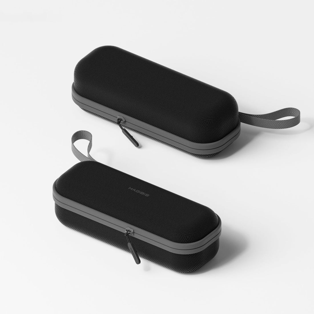 Two black carrying cases with gray zippers on a white background