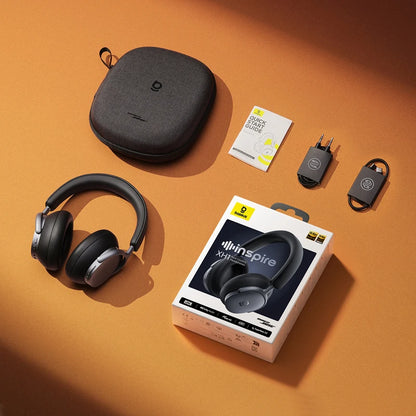 Kinspire headphones with carrying case, quick start guide, and wall adapter on an orange background
