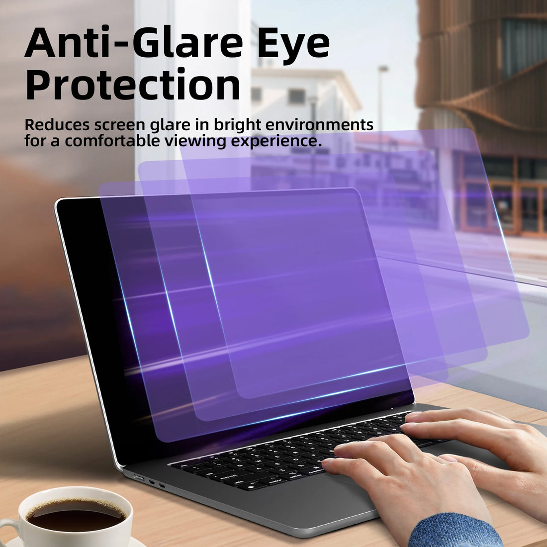 Laptop with an anti-glare screen protector on a desk with a cup of coffee, in front of a window.