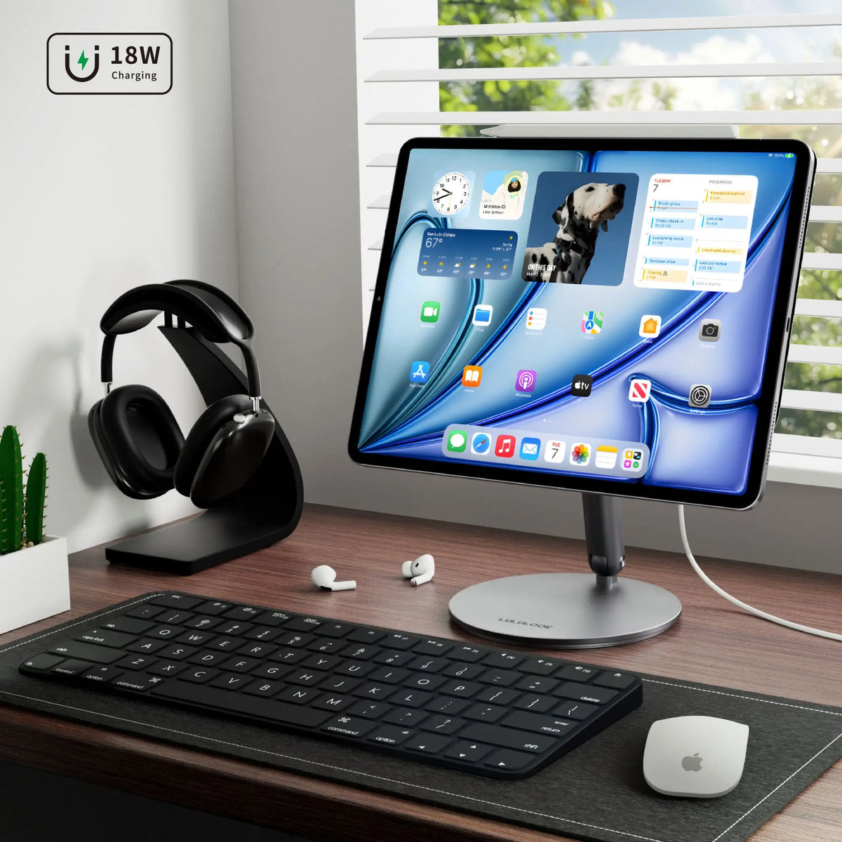 Modern desk setup with computer monitor, keyboard, mouse, and headphones on a wooden desk.