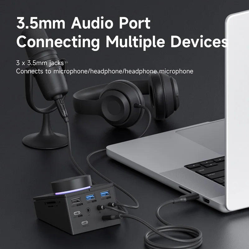 3.5mm audio port connection setup with laptop, microphone, and headphones on a dark surface.