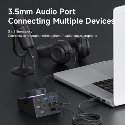 3.5mm audio port connection setup with laptop, microphone, and headphones on a dark surface.
