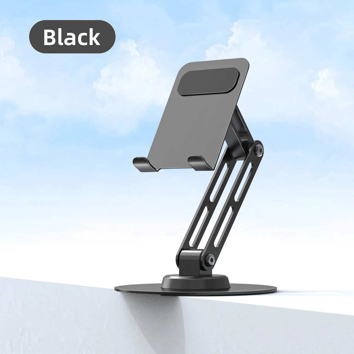 Black adjustable phone stand on a white surface with a blue sky background