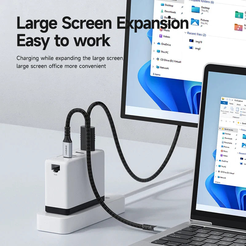 Laptop with screen expansion device and charging cable on a white surface