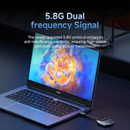 Laptop with a colorful screen displaying a flower design, connected to a USB device on a dark background.
