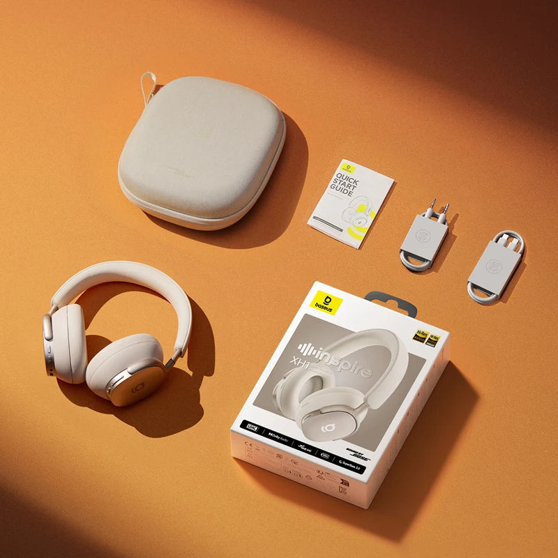 Beige headphones with carrying case, charging cable, and packaging on an orange background