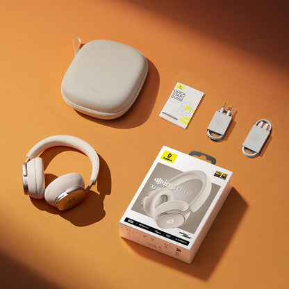 Beige headphones with carrying case, charging cable, and packaging on an orange background