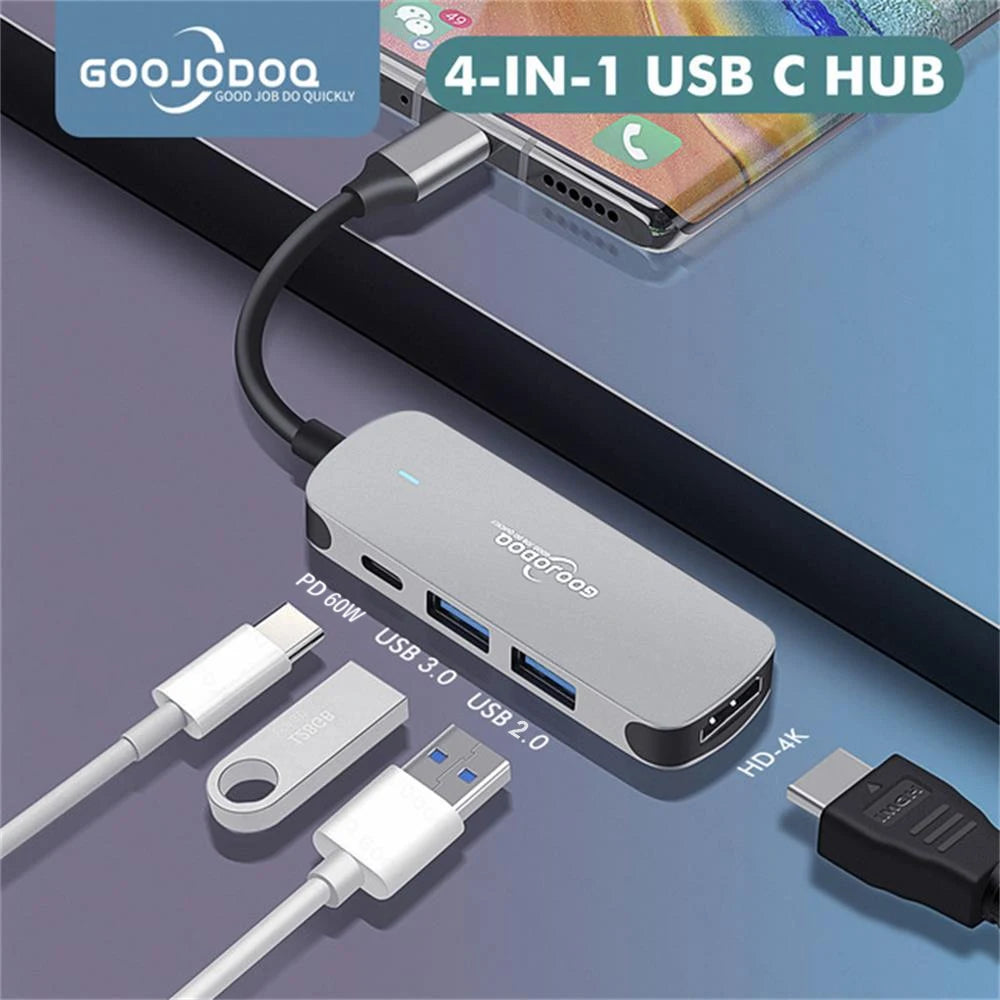 A silver 4-in-1 USB C hub with HDMI, USB Type-C, and USB ports, connected to a phone charger.