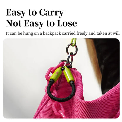 Pink backpack with a green and yellow keychain attached, on a white background.