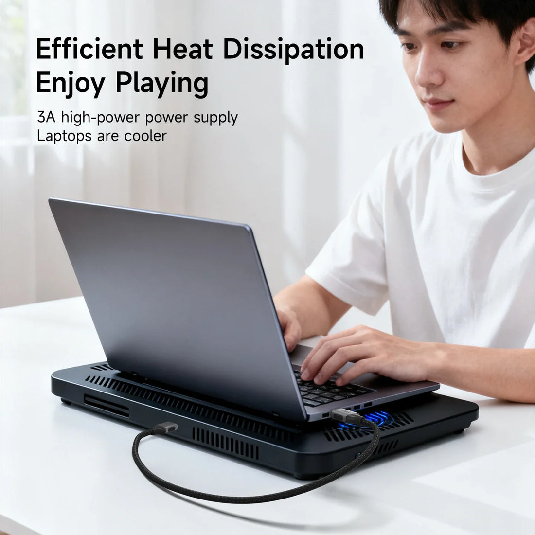 Person using a laptop with a cooling pad on a white surface, with text about heat dissipation.
